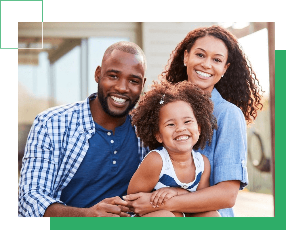 Young black family embracing outdoors and smiling at camera